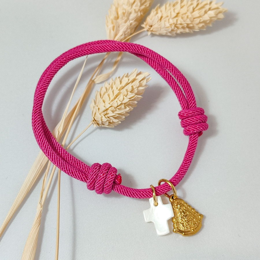 Pulsera de cuerda fucsia con cruz de nácar y Virgen del Rocío de acero