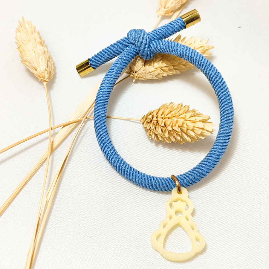 Pulsera de cuerda elástica azul y Virgen del Rocío de acetato